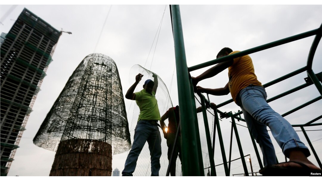 Construction workers work on a huge Christmas tree in an attempt to construct the world's tallest Christmas tree, in Colombo, Sri Lanka, Dec. 20, 2016.
