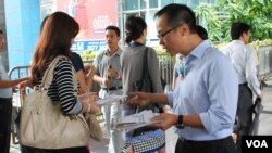 香港立法會選舉會計界參選人梁繼昌(右)在街上向市民派發傳單