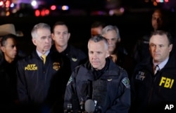 Austin Police Chief Brian Manley, center, stands with other members of law enforcement as he briefs the media, March 21, 2018, in the Austin suburb of Round Rock, Texas.