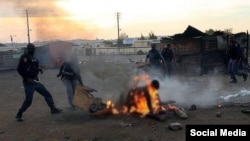 La police tente de secourir un homme brulé lors des violences xénophobes en Afrique du Sud (Image d'archive 2008).