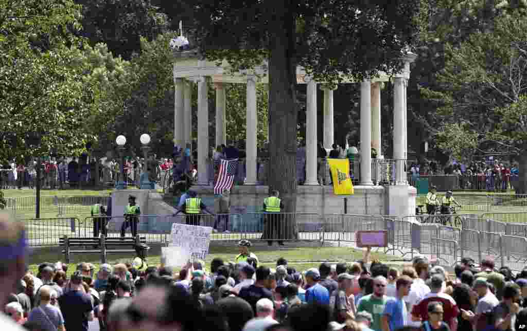 Organizers stand on the bandstand on Boston Common during a "free speech" rally staged by conservative activists, in Boston, Aug. 19, 2017. Counterprotesters stand along barricades ringing the bandstand. 