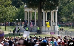 Organizers stand on the bandstand on Boston Common during a "free speech" rally staged by conservative activists, in Boston, Aug. 19, 2017. Counterprotesters stand along barricades ringing the bandstand.