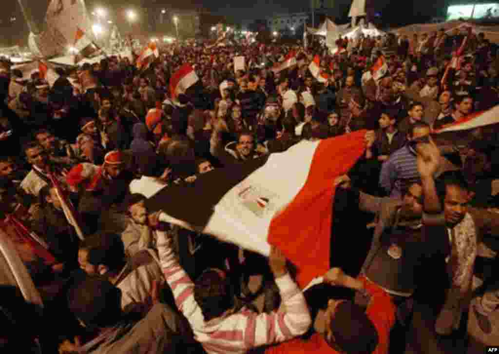 Egyptian citizens wave their country's flag as they celebrate after President Hosni Mubarak resigned and handed power to the military at Tahrir square, in Cairo, Egypt, Friday, Feb. 11, 2011. Egypt exploded with joy, tears, and relief after pro-democracy 