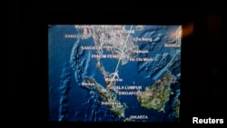 A screen on board Malaysia Airlines Boeing 777-200ER flight MH318 shows the plane's flight path as it cruises over the South China Sea from Kuala Lumpur towards Beijing, at approximately the same point when on March 8 flight MH370 lost contact with air tr