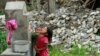 30일 지진 피해를 입은 네팔 발루아 마을에서 한 소녀가 아기를 안은 채 식수대의 물을 마시고 있다.