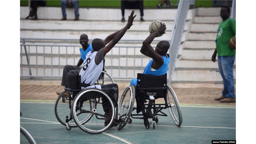 A wheelchair basketball player tries to block a pass by an opponent at a basketball court in Juba, South Sudan, May 24, 2016.