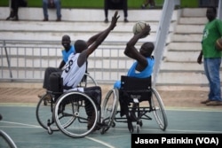 A wheelchair basketball player tries to block a pass by an opponent at a basketball court in Juba, South Sudan, May 24, 2016.