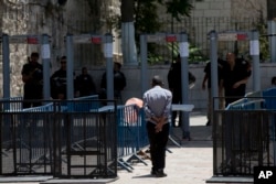 FILE - A Palestinian man walks towards a metal detector at the Al Aqsa Mosque compound in Jerusalem's Old City, July 19, 2017. A dispute over metal detectors has escalated into a new showdown between Israel and the Muslim world.
