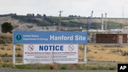 FILE - A sign informs visitors of prohibited items on the Hanford Nuclear Reservation near Richland, Wash. A new report says Congress should consider authorizing the Department of Energy to use grout to stabilize some of Hanford's radioactive waste, rather than a more expensive plan to turn it into glass, July 9, 2014.