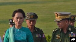 Aung San Suu Kyi, Myanmar's foreign minister and de facto leader, left walks with senior General Min Aung Hlaing, Myanmar's commander-in-chief, right in the airport of capital Naypyitaw, Myanmar on May 6, 2016.