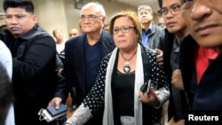 Philippine Senator Leila de Lima is escorted by the Senate's security personnel after a Regional Trial Court ordered her arrest, at the Senate headquarters in Pasay city, metro Manila, Philippines. Feb. 23, 2017.