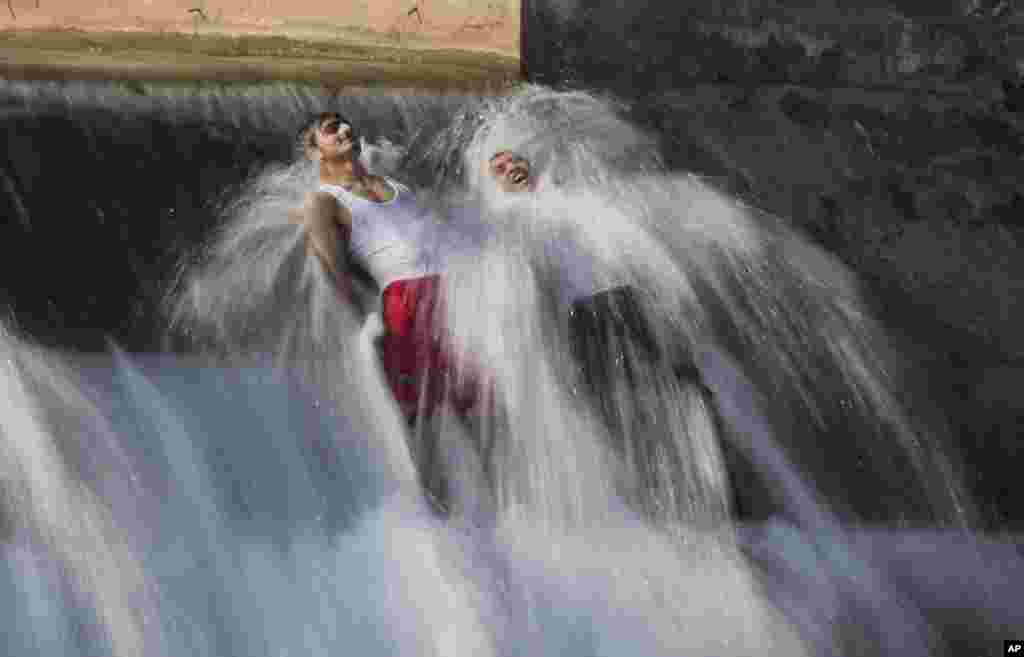 Pakistani men bathe in a stream to beat the heat on the outskirts of Islamabad.