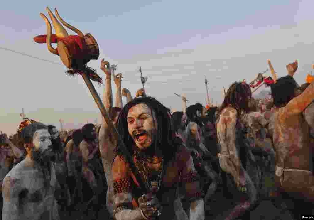 A Hindu holy man shouts while holding a "trishul" or trident-shaped weapon after taking a dip during the second grand bath of the ongoing Kumbh Mela, Allahabad, Feb. 10, 2013.