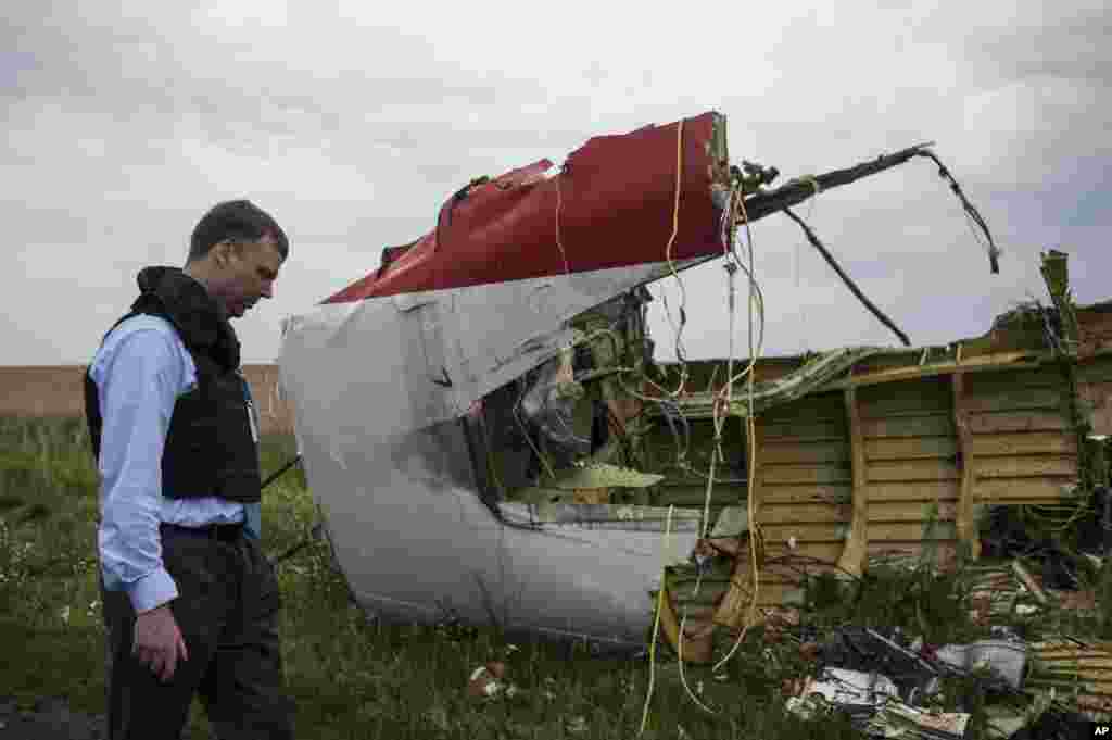 Alexander Hug, deputy head of the OSCE mission, looks at debris at the crash site of a Malaysia Airlines jet near the village of Hrabove, eastern Ukraine, July 18, 2014.