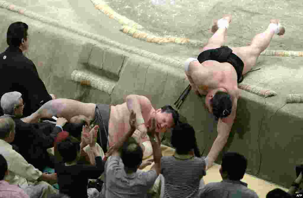 Yokozuna Hakuho of Mongolia (L) is pushed out by his compatriot and yokozuna rival Harumafuji (R) on the final day of the 15-day Summer Grand Sumo Tournament in Tokyo, Japan.