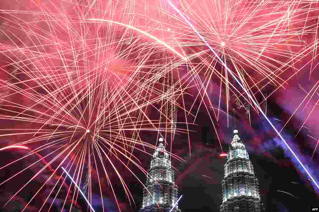 Fireworks illuminate the sky near Malaysia&#39;s Petronas Twin Towers during New Year celebrations in Kuala Lumpur.