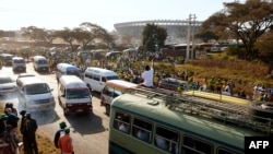 Les partisans du ZANU-PF se tiennent dans les rues de Harare après avoir assisté au rassemblement de leur parti avant les élections générales du Zimbabwe le 28 juillet 2018.