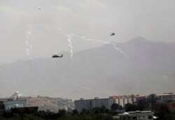 Američki transportni helikopteri Blek houk ispuštaju termalne mamce dok lete iznad krovova Kabula, Avganistan, 15. avgusta 2021.
