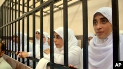 Egyptian women supporters of ousted President Mohamed Morsi stand inside the defendants' cage in a courtroom in Alexandria, Egypt, Nov. 27, 2013.