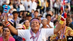 An Anti-government protester waves clapping tools at Democracy Monument in Bangkok, Thailand. (Dec. 7, 2013.) 