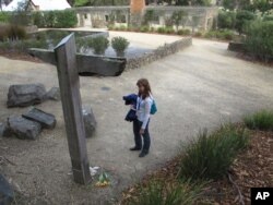 FILE - A tourist reads names on a memorial, at Port Arthur, Tasmania state, Australia, where 35 people were killed by a lone gunman, April 18, 2016. The 1996 massacre galvanized Australia to drastically clamp down on guns.