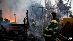 Petugas pemadam kebakaran berupaya memadamkan kobaran api di sebuah rumah di Haifa, Israel, 24 November 2016 (AP Photo/Ariel Schalit).