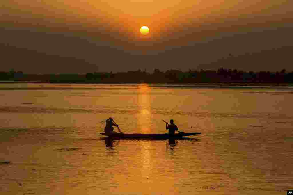 បុរស​ម្នាក់​ទាញ​សំណាញ់​ចេញ​ពី​ទូកនេសាទ​មួយ​អំឡុងពេល​ថ្ងៃ​លិច​នៅ​បឹង Dal Lake ក្នុង​ក្រុង Srinagar នៃ​តំបន់​កាស្មៀ​គ្រប់គ្រង​ដោយ​ប្រទេស​ឥណ្ឌា។&nbsp;