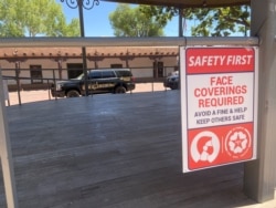 A sign in the plaza tells people to wear a face mask or face a fine under a city law, amid the coronavirus disease (COVID-19) outbreak, in Santa Fe, New Mexico, U.S., July 9, 2020. (REUTERS/Andrew Hay)