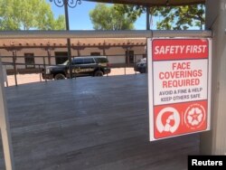 A sign in the plaza tells people to wear a face mask or face a fine under a city law, amid the coronavirus disease (COVID-19) outbreak, in Santa Fe, New Mexico, U.S., July 9, 2020. (REUTERS/Andrew Hay)