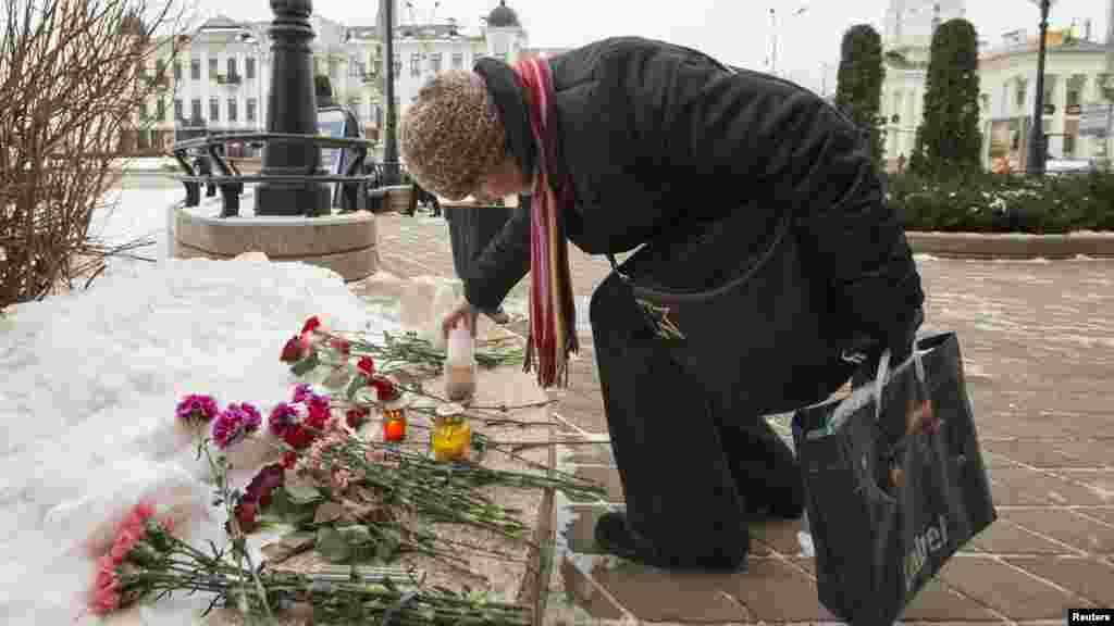 Une femme allume une bougie de condoléances à l&#39;ambassade française à Minsk, en Biélorussie, le 8 janvier 2015.