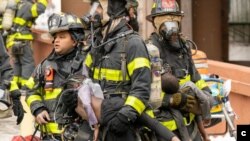 Des pompiers secourent les victimes de l'incendie qui s'est déclaré dans un immeuble du 19 dans le Bronx, à New York, aux États-Unis, dimanche 9 janvier 2022 au matin. (Photo : Theodore Parisienne/pour New York Daily News)