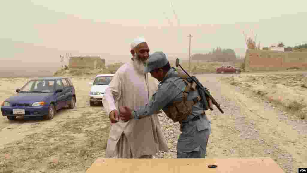 یک سرباز افغان در حال تلاشی مردم برای تامین بهتر امنیت