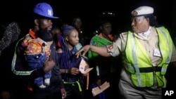 An unidentified Immigration officer, right, speaks to Nigerian returnees from Libya upon arrival at the Murtala Muhammed International Airport in Lagos Nigeria, Dec. 5, 2017. 