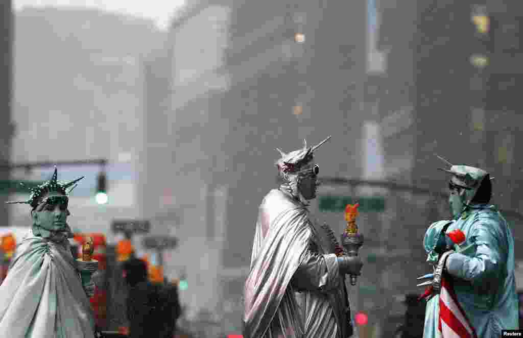 Artis jalanan berpakaian patung Liberty di tengah-tengah hujan salju di Times Square, New York, 3 Maret 2015.