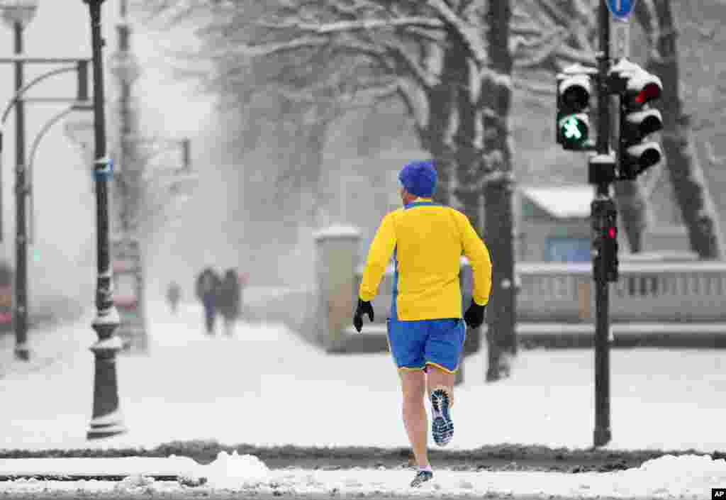 A jogger braves the cold temperatures and the snow in shorts in Berlin, Germany.