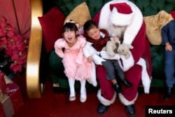 A girl laughs while her brother cries being held by Santa Claus at the King of Prussia Mall, in King of Prussia, Pennsylvania, U.S., December 8, 2018.