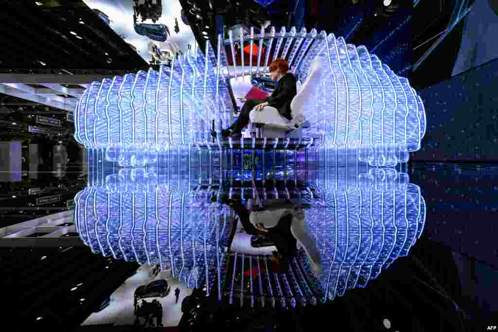 A woman poses inside the mockup of a car at the Opel booth during the press day of the Geneva Car Show in Switzerland.