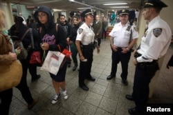Members of the New York Police Department stand and talk at the Times Square subway station in the Manhattan borough of New York, Sept. 25, 2014.