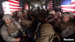 U.S. Marines are seen on board a helicopter at Kandahar air base upon the end of operations for the Marines and British combat troops in Helmand province, Oct. 27, 2014. 