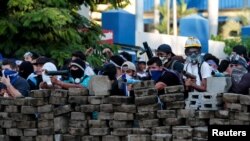 Des manifestants se tiennent derrière une barricade lors d'une manifestation contre le gouvernement du président Daniel Ortega, à Managua, au Nicaragua, le 30 mai 2018. REUTERS / Oswaldo Rivas