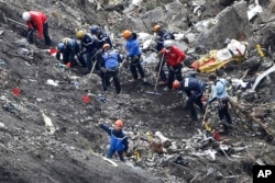 Rescue workers work on debris of the Germanwings jet at the crash site near Seyne-les-Alpes, France, March 26, 2015.