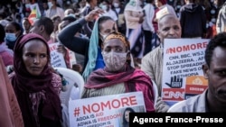 People hold papers showing messages of "No More" as they protest against purported fake news during the send-off ceremony for new military recruits who are joining the Ethiopian National Defence Force in Addis Ababa, Ethiopia, Nov. 24, 2021.