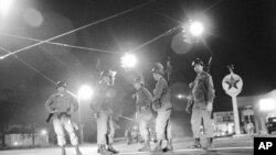 FILE - In this May 12, 1970, file photo, Georgia National Guard troops stand at an intersection at the edge of the riot-torn area of town in Augusta, Georgia. 