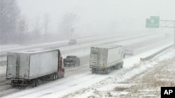 Truk melintasi jalan tol di North Ridgeville, negara bagian Ohio (26/12) di tengah badai salju. (AP/Mark Duncan)