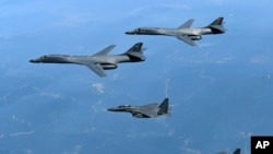 FILE - In this June 20, 2017, file photo provided by South Korean Defense Ministry, U.S. Air Force B-1B bombers, top, and second from top, and South Korean fighter jets F-15K fly over the Korean Peninsula, South Korea. A South Korean lawmaker said Oct. 10, 2017, that North Korean hackers may have stolen highly classified military documents that include U.S.-South Korean wartime "decapitation strike" plans against the North.