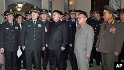 North Korean leader Kim Jong Il, in light gray, and his son Kim Jong Un, center, look at a gift from Gen. Guo Boxiong, vice chairman of China's Central Military Commission, second left in front, in Pyongyang, North Korea, Oct 25, 2010 (file photo)