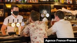 Customers sit at a bar on the first day of reopening in Auckland, New Zealand, on Dec. 3, 2021, as the country revamps its domestic COVID-19 response.