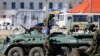 乌克兰军事基地前面疑似俄罗斯军人的武装人员及其装甲运兵车。