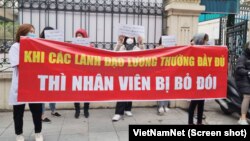 Nhân viên y tế Bệnh viện Tuệ Tĩnh căng băng rôn biểu tình trước cổng bệnh viện ở Hà Nội đòi được trả lương bị nợ trong 8 tháng qua.