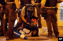 FILE - Police arrest a man as demonstrators march in response to a not guilty verdict in the trial of former St. Louis police officer Jason Stockley, Sunday, Sept. 17, 2017, in St. Louis.